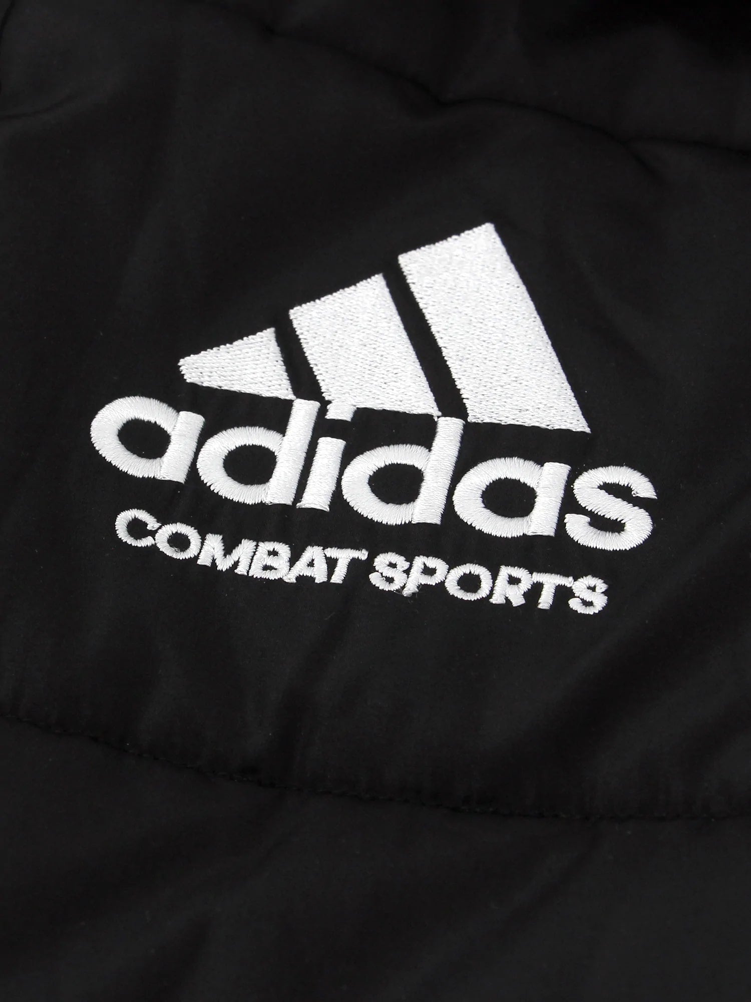 Close-up of a black adidas combat sports padded parka jacket.