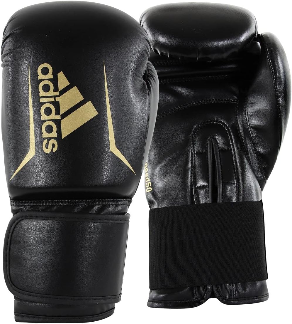Black boxing gloves with gold Adidas logo on a black background