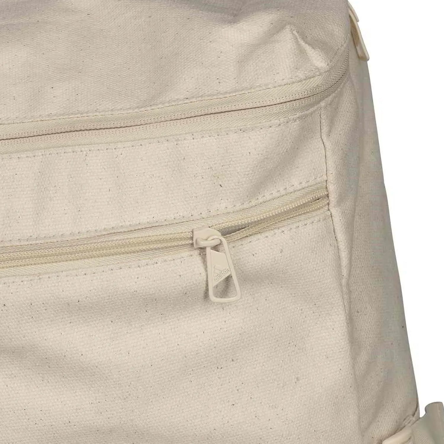 close up image of tan backpack showing a zipped pocket