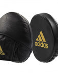 Pair of black boxing pads with gold details.