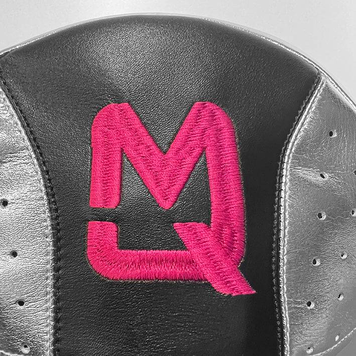 Close-up of a shoe with a pink logo on a gray background