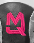 Close-up of a shoe with a pink logo on a gray background