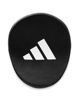 Black circular object with Adidas logo on a white background