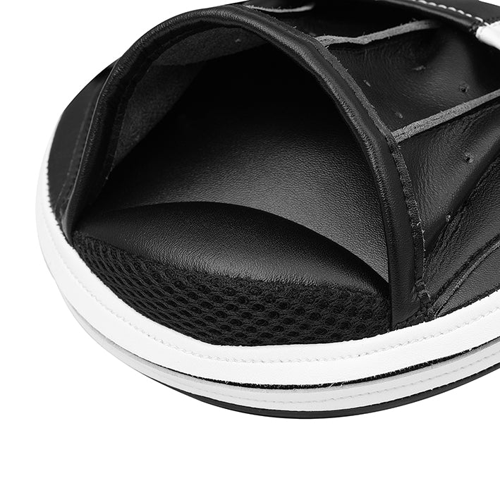 Close-up of a black sandal with white sole on a white background