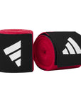 Red and black hand wraps for boxing, Adidas branding visible.