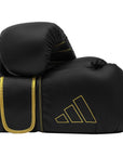 Black boxing gloves with gold trim, Adidas Hybrid 80, 12 oz.