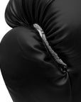 Close up of a black boxing glove with white trim.