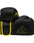 Pair of black and yellow Adidas Hybrid 80 boxing gloves.