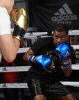 A man wearing boxing gloves inside a ring.