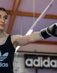 A woman wearing adidas Hybrid 150 boxing gloves.