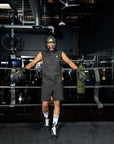 A man wearing boxing gloves and helmet stands in a boxing ring.
