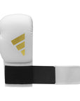 White boxing glove with black straps displayed against a neutral background.