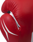 Close-up of a red boxing glove with white stitching on a white background