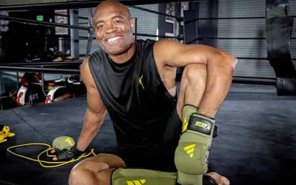 Anderson Silva sitting wearing adidas boxing gloves. 