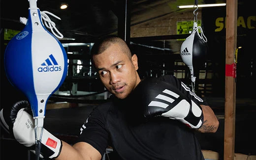 Mercito hitting an adidas speed bag with gloves on during his training. 