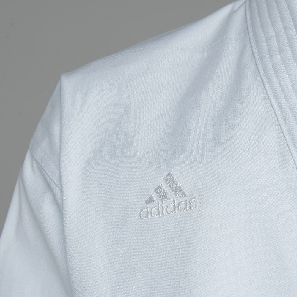 Close-up of white karate uniform by Adidas.