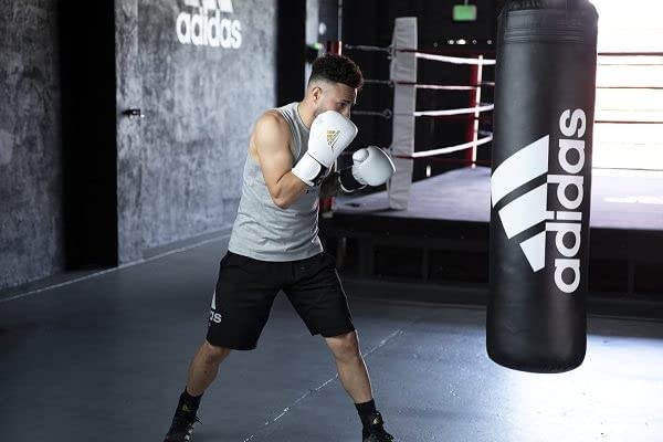 Man wearing boxing gloves standing in a boxing ring.