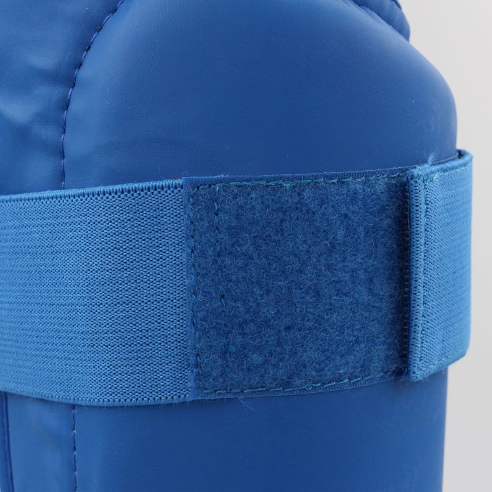 Blue karate shin guard with a velcro strap.