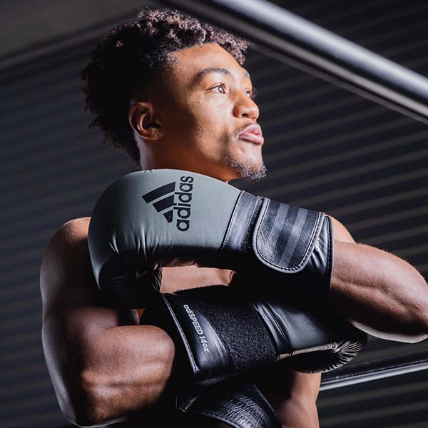 Man wearing adiSPEED 501 PRO boxing gloves.