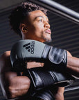 Man wearing adiSPEED 501 PRO boxing gloves.