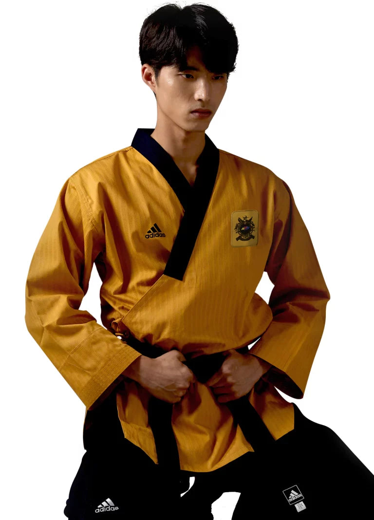 Man wearing a yellow taekwondo uniform with black belt.