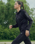 A woman in black running, wearing adidas Women's Hydrosuit.