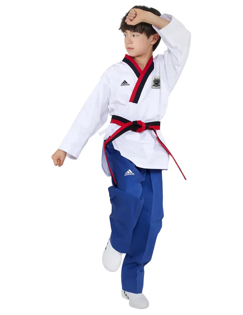 Boy wearing Adidas Poomsae taekwondo uniform in white and blue.