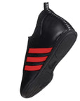 Black and red adidas laceless taekwondo shoe.