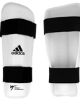 White and black Adidas vinyl shin guards for Taekwondo sparring gear.