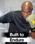 A man wearing Adidas x Anderson Silva boxing gloves.