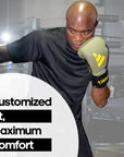 A man wearing Adidas x Anderson Silva boxing gloves.