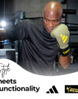 A man wearing Adidas x Anderson Silva boxing gloves.