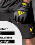 Person wearing black shorts and Adidas x Anderson Silva gloves.