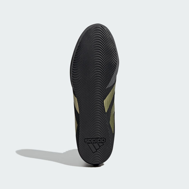 Black shoe with gold stripes designed for boxing.