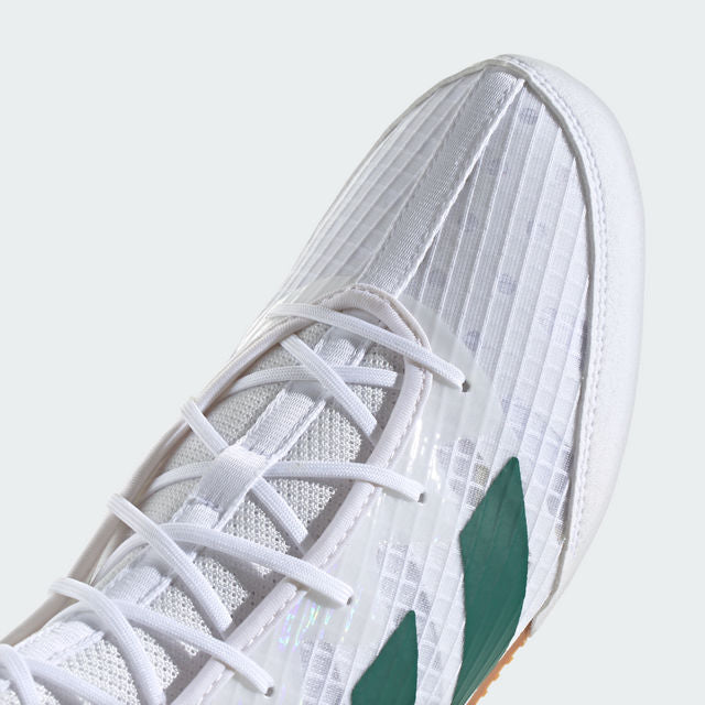 White sneaker with green accents on a light gray background