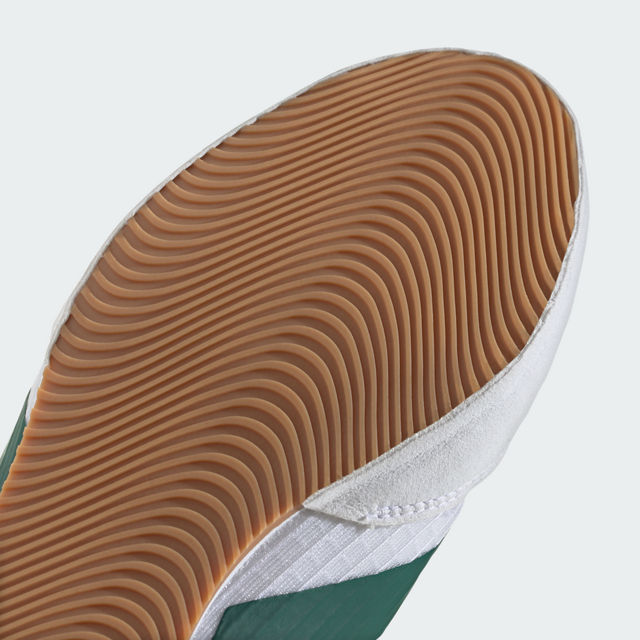Close-up of a shoe sole with brown tread pattern on a light gray background