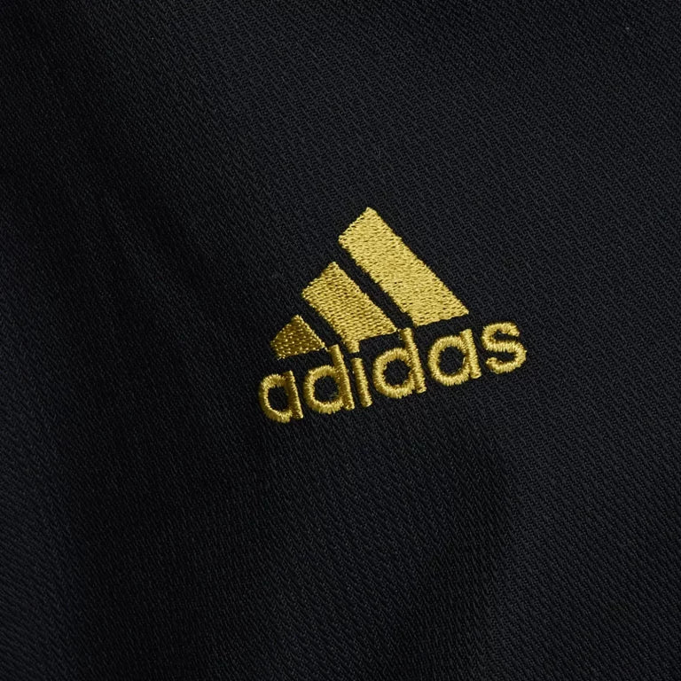 Black shirt with yellow logo from Adidas.