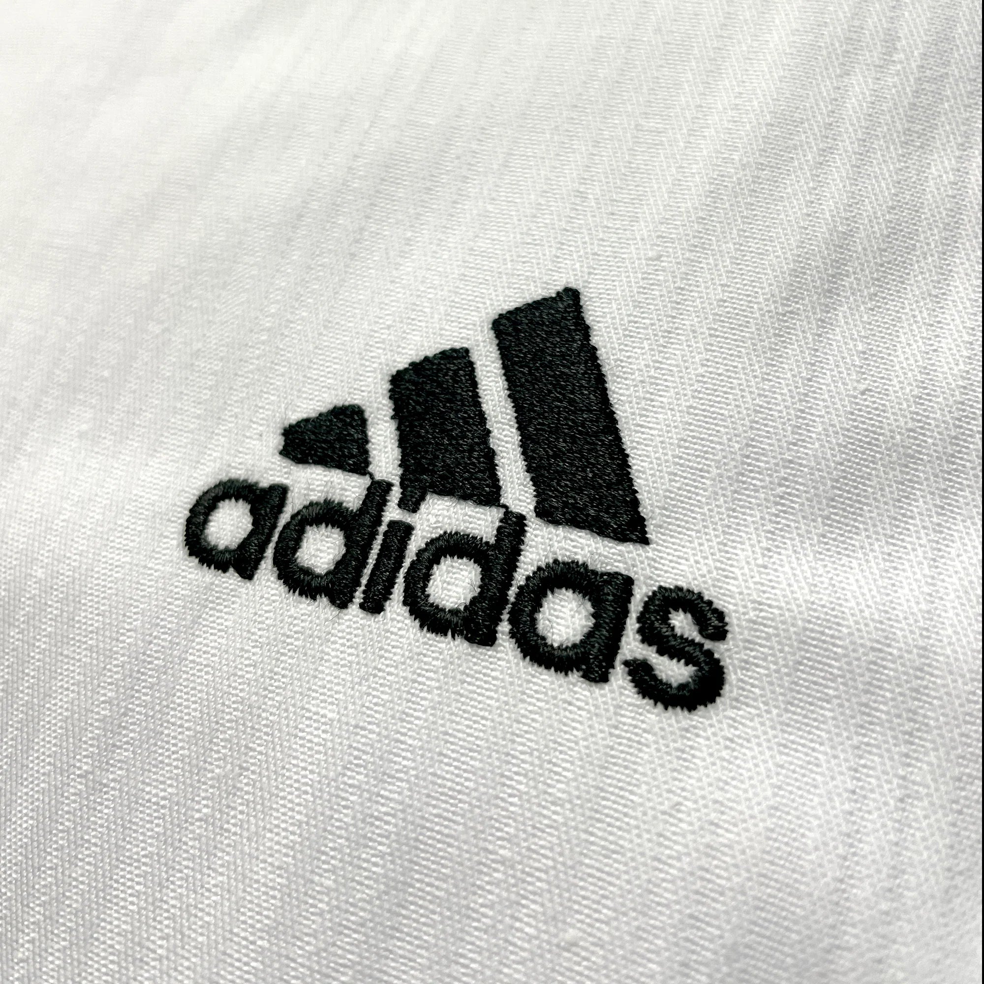 Close-up of Taekwondo uniform&#39;s black V-neck logo.