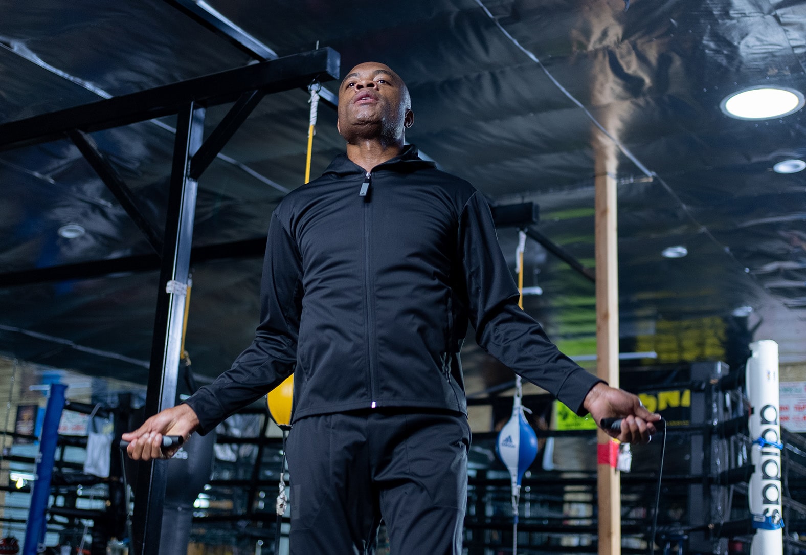 Man in black jacket holding an Adidas skipping rope.