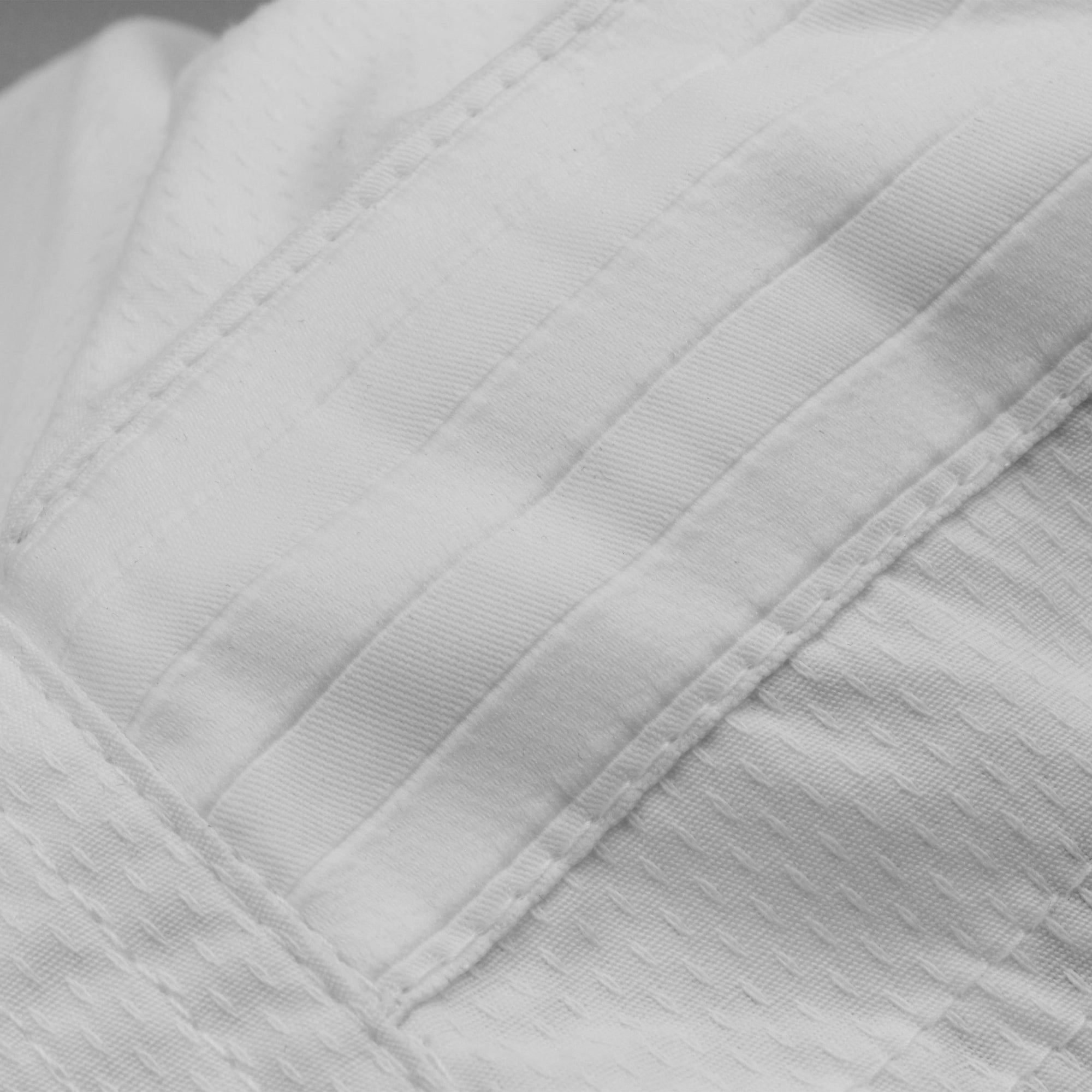 Close-up of white karate uniform fabric texture.