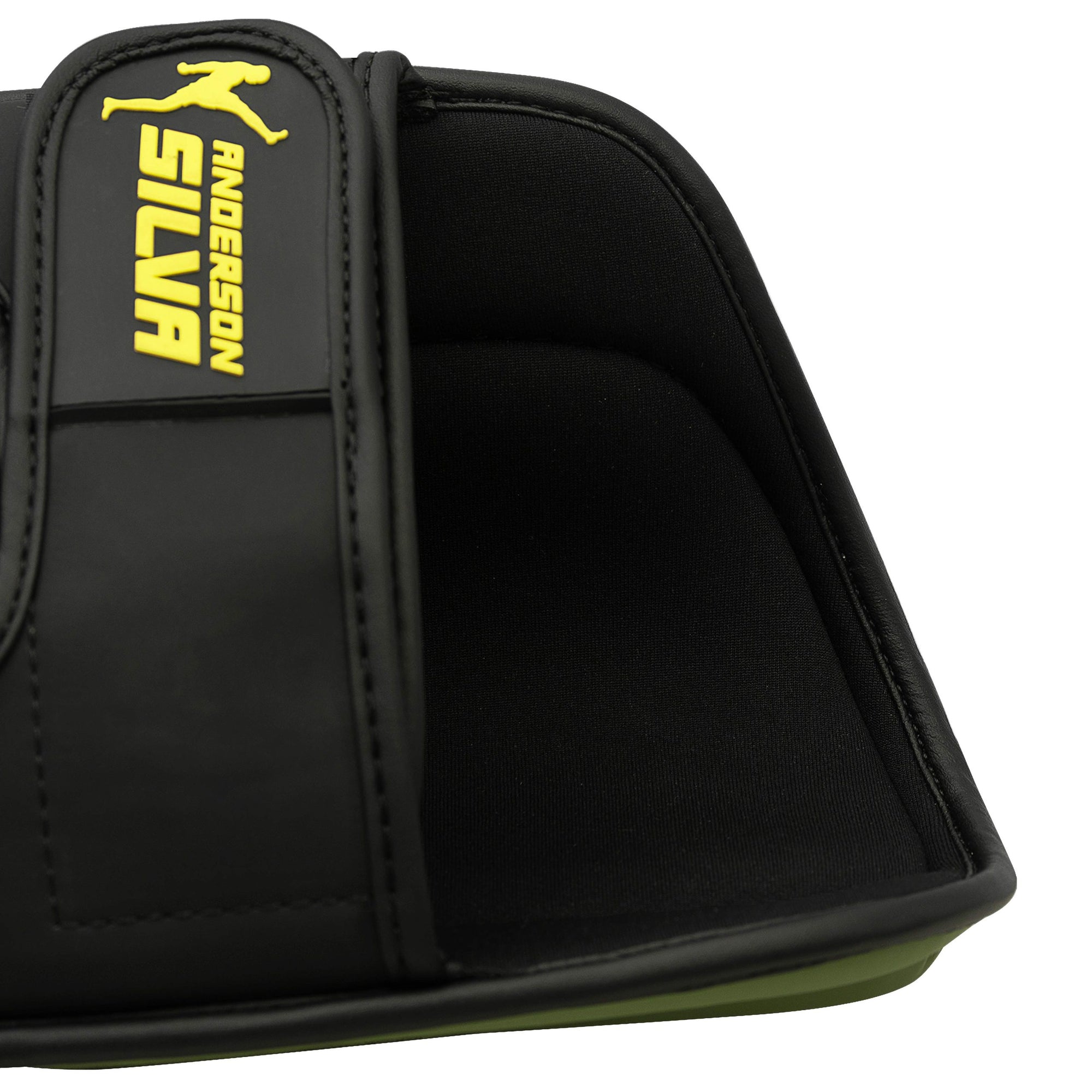 Black glove with a yellow logo on a shin protector.