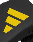 Close-up of black glove with yellow Adidas logo.