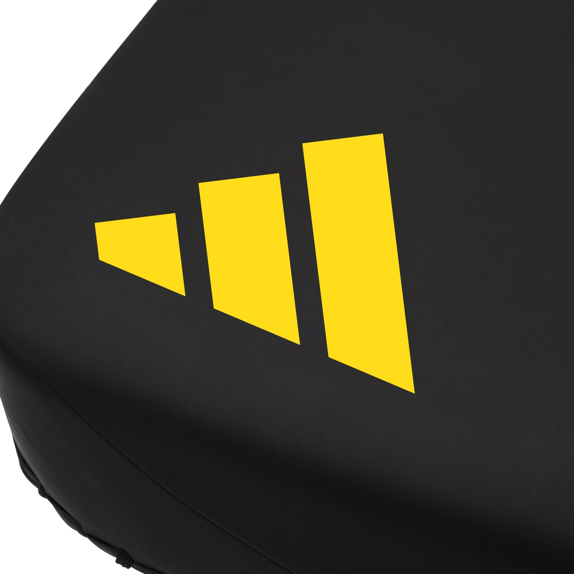 Close-up of black Adidas x Anderson Silva thigh pad featuring yellow logo for MMA training.