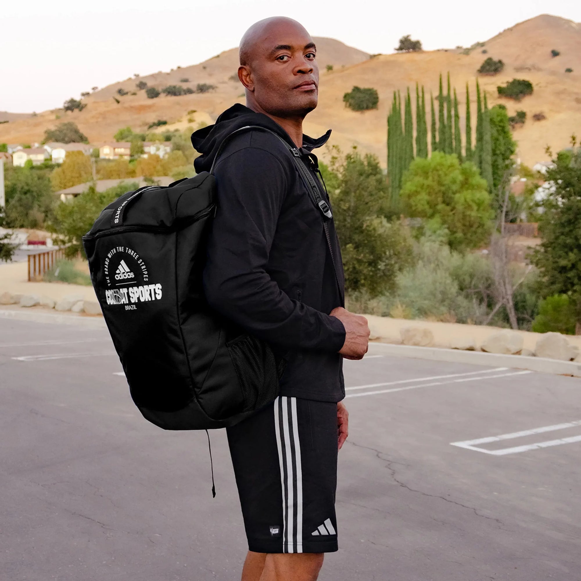 A man wearing a backpack in a parking lot, no clear connection to product.