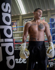 Man wearing boxing gloves in a boxing ring.