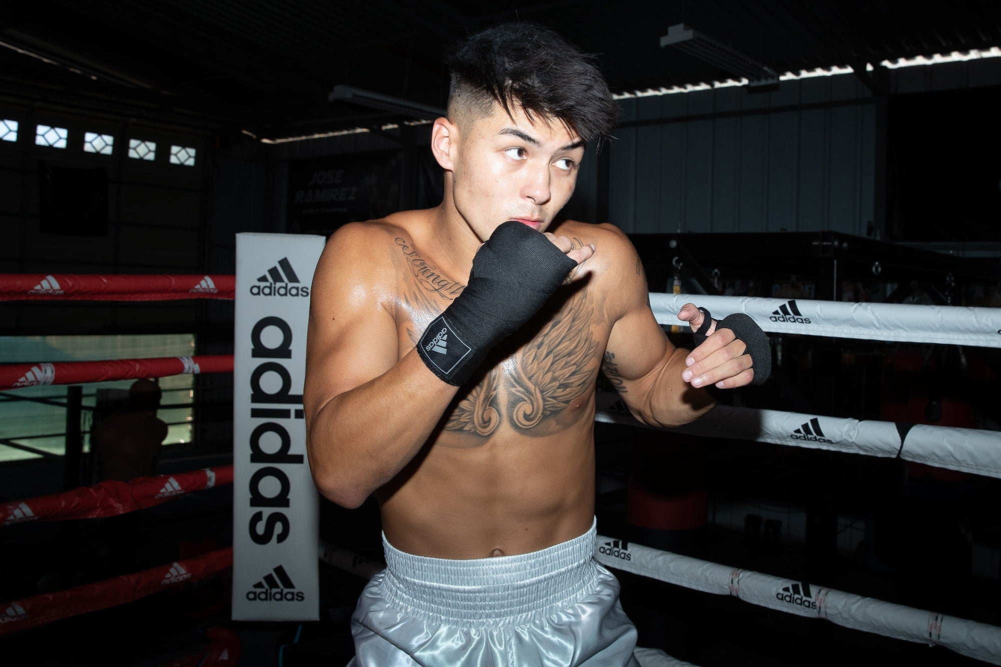 A man in boxing gloves preparing for a fight, showcasing protective equipment.