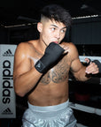 A man in boxing gloves preparing for a fight, showcasing protective equipment.