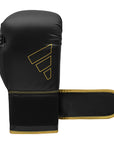 A black boxing glove with gold trim designed for boxing training.