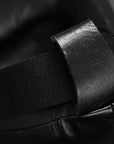 Black strap on a boxing glove, part of groin guard equipment.