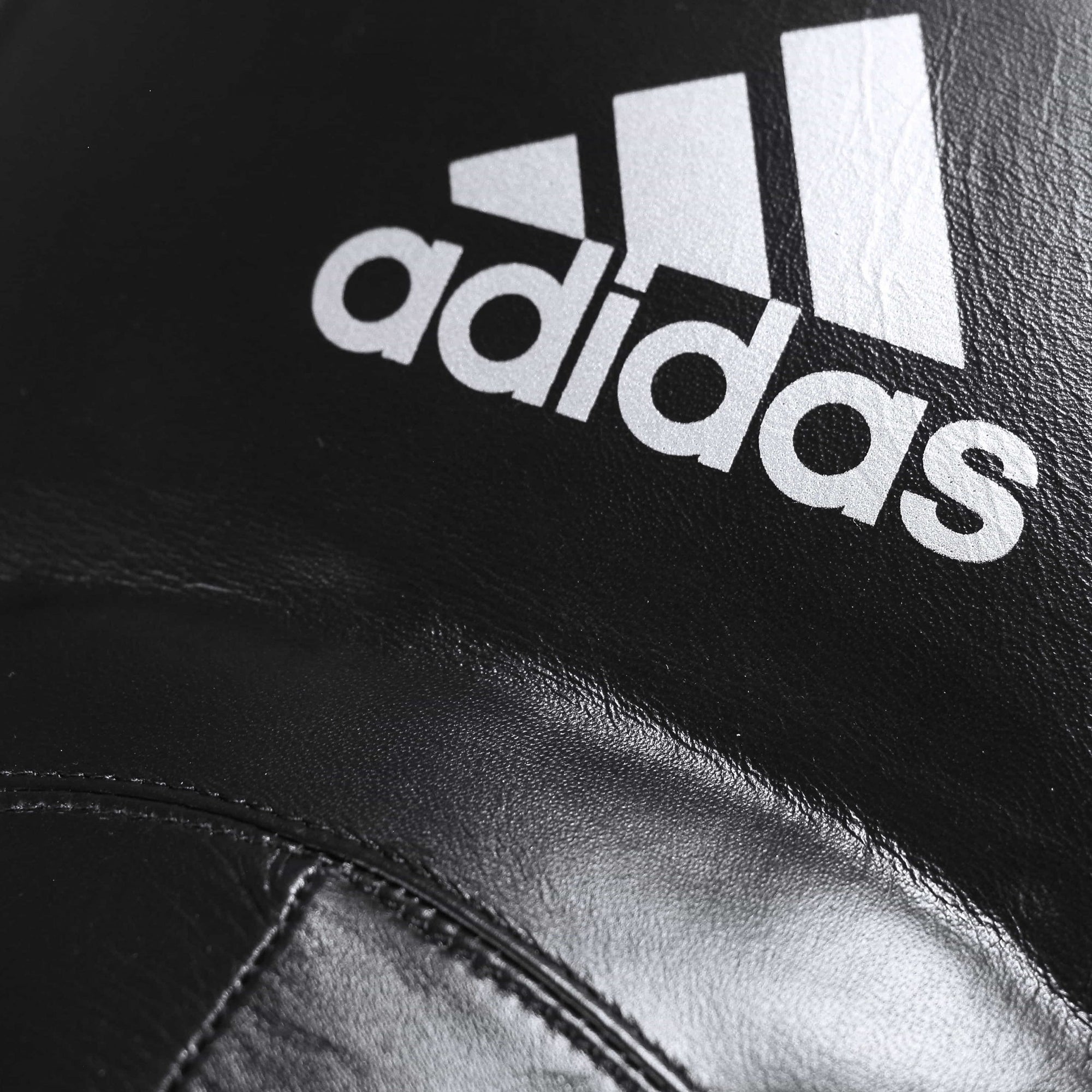 Close-up of black boxing groin protector with white detailing.